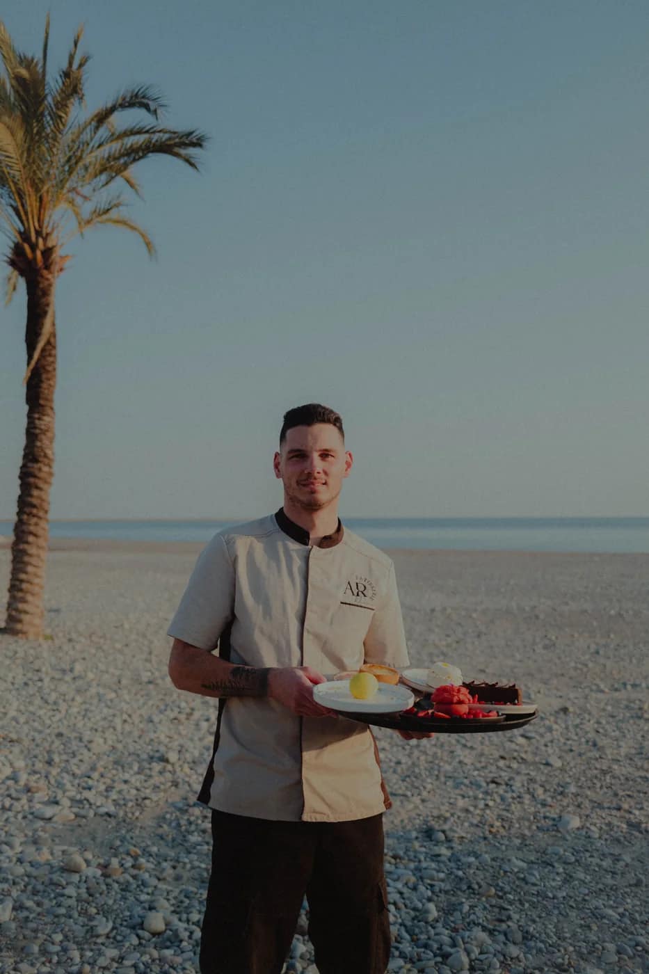 Adrien, chef pâtissier de Maison Manou, une assiette à la main