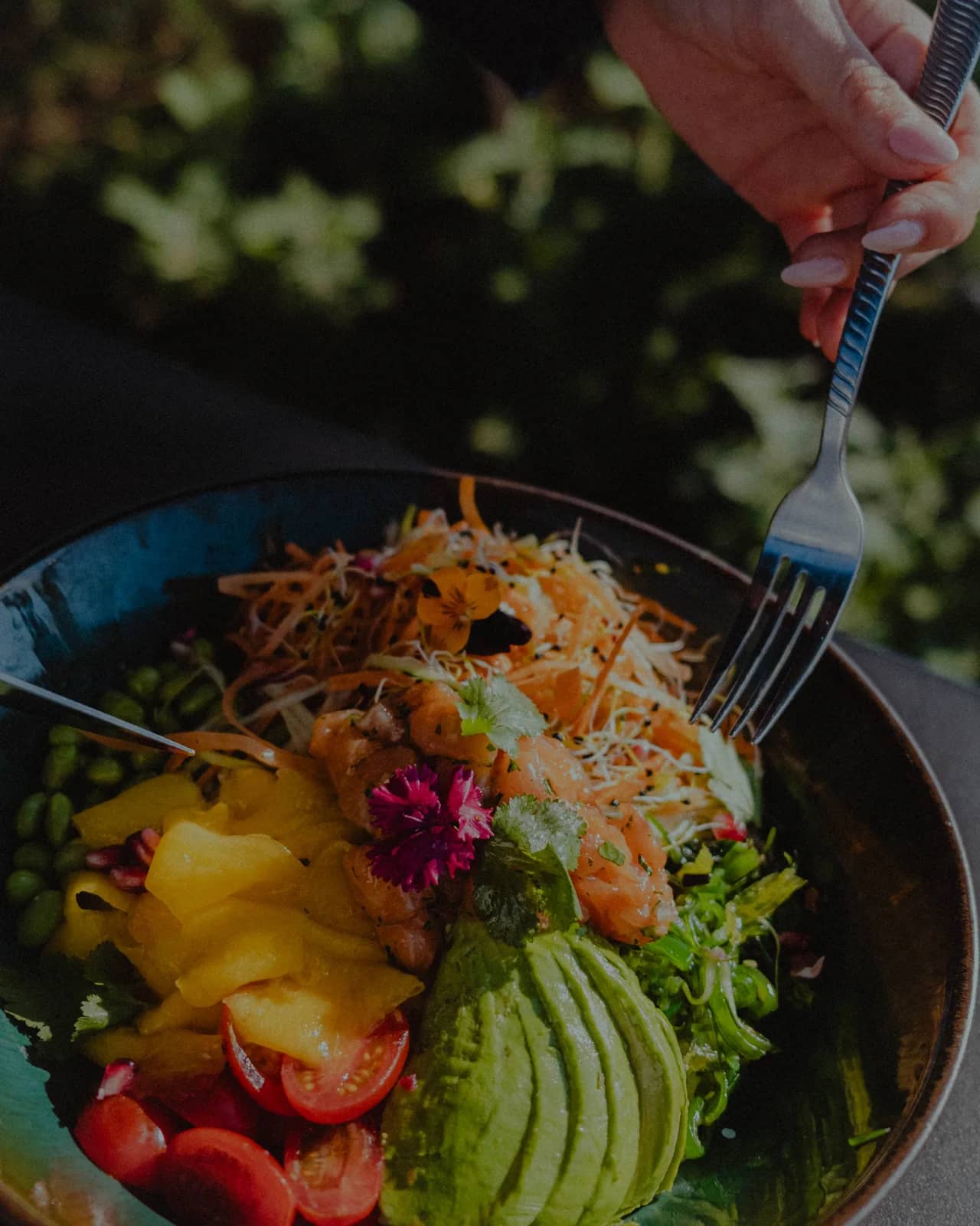 Poke bowl coloré : avocat, mangue, tomates cerises et jeunes pousses