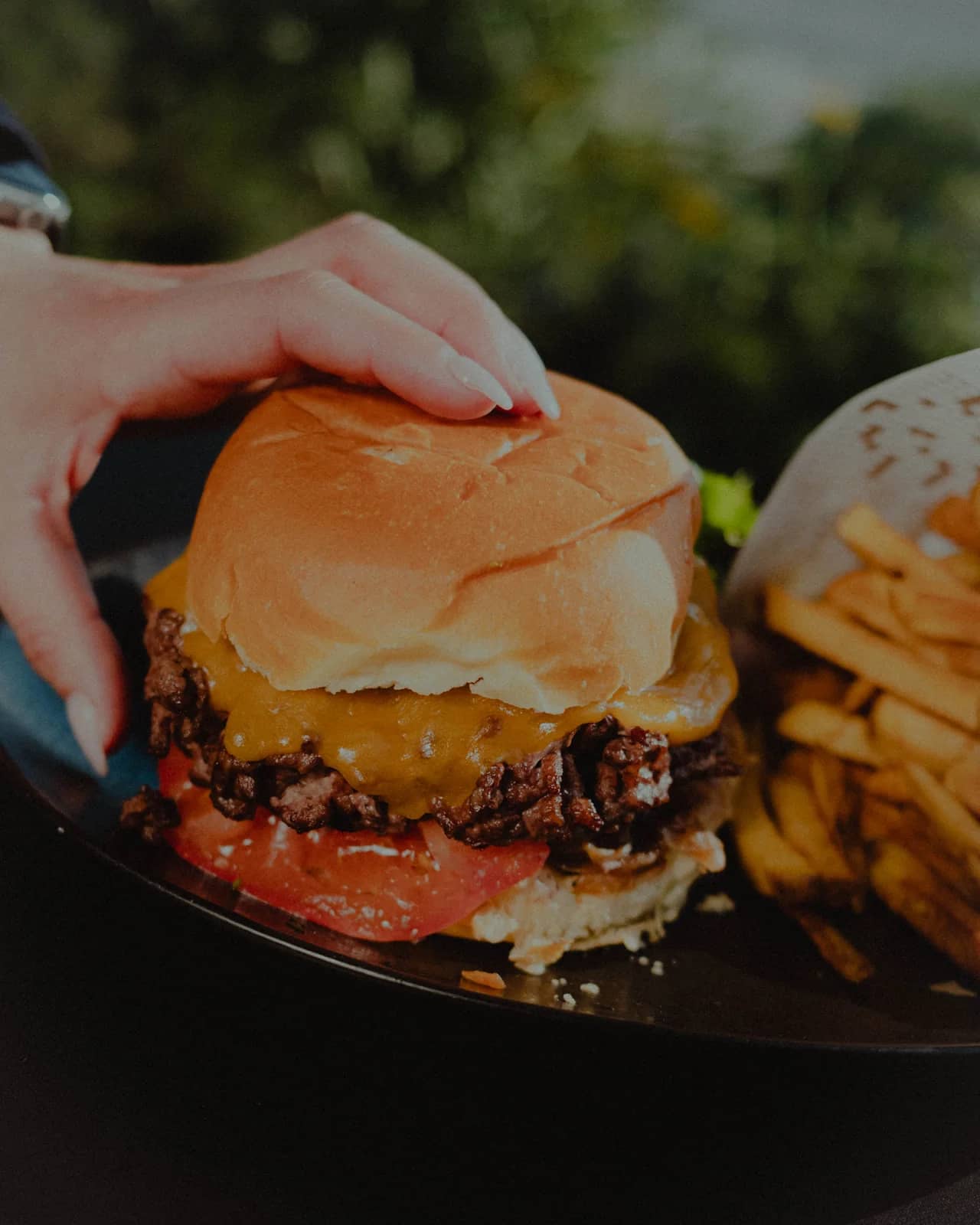Burger maison et frites, servis en terrasse face à la mer