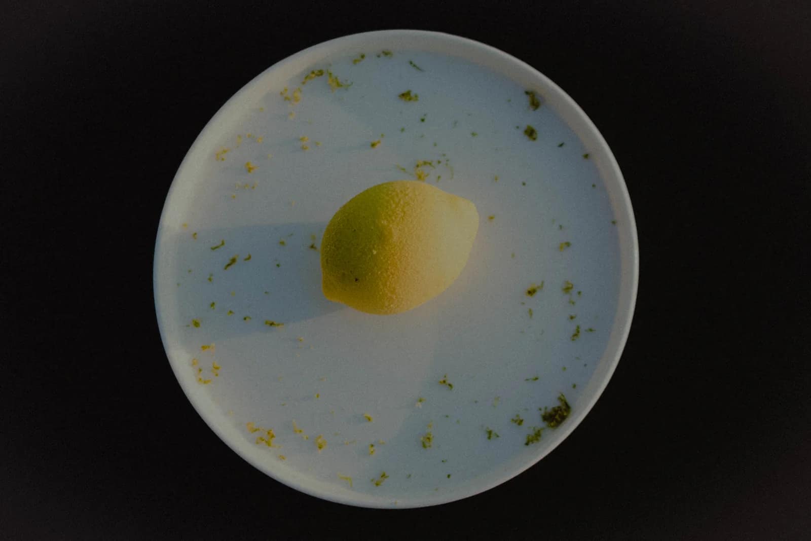 Le trompe-l'œil citron vu de dessus, seul au centre de l'assiette