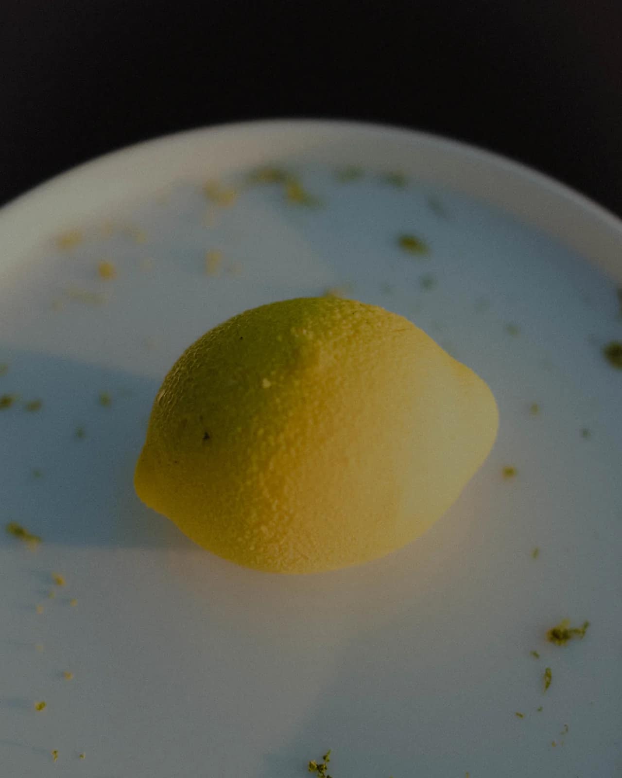 Trompe-l'œil en forme de citron, posé sur une assiette claire
