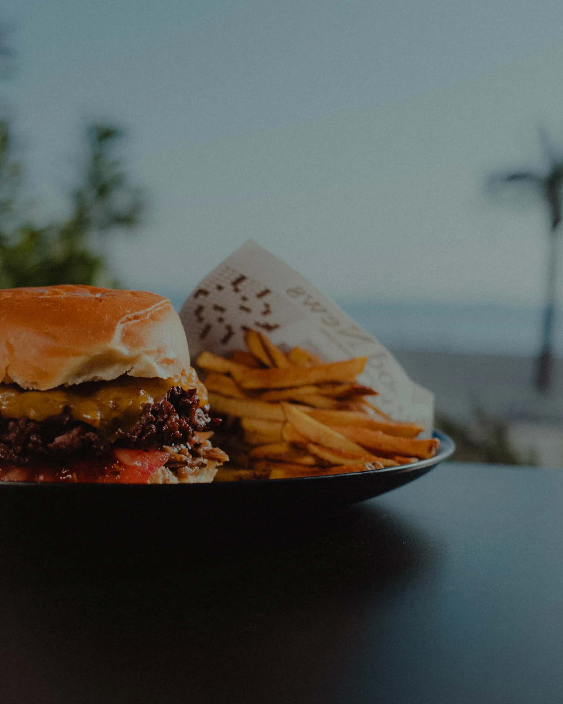 Burger maison servi en terrasse, la mer en arrière-plan