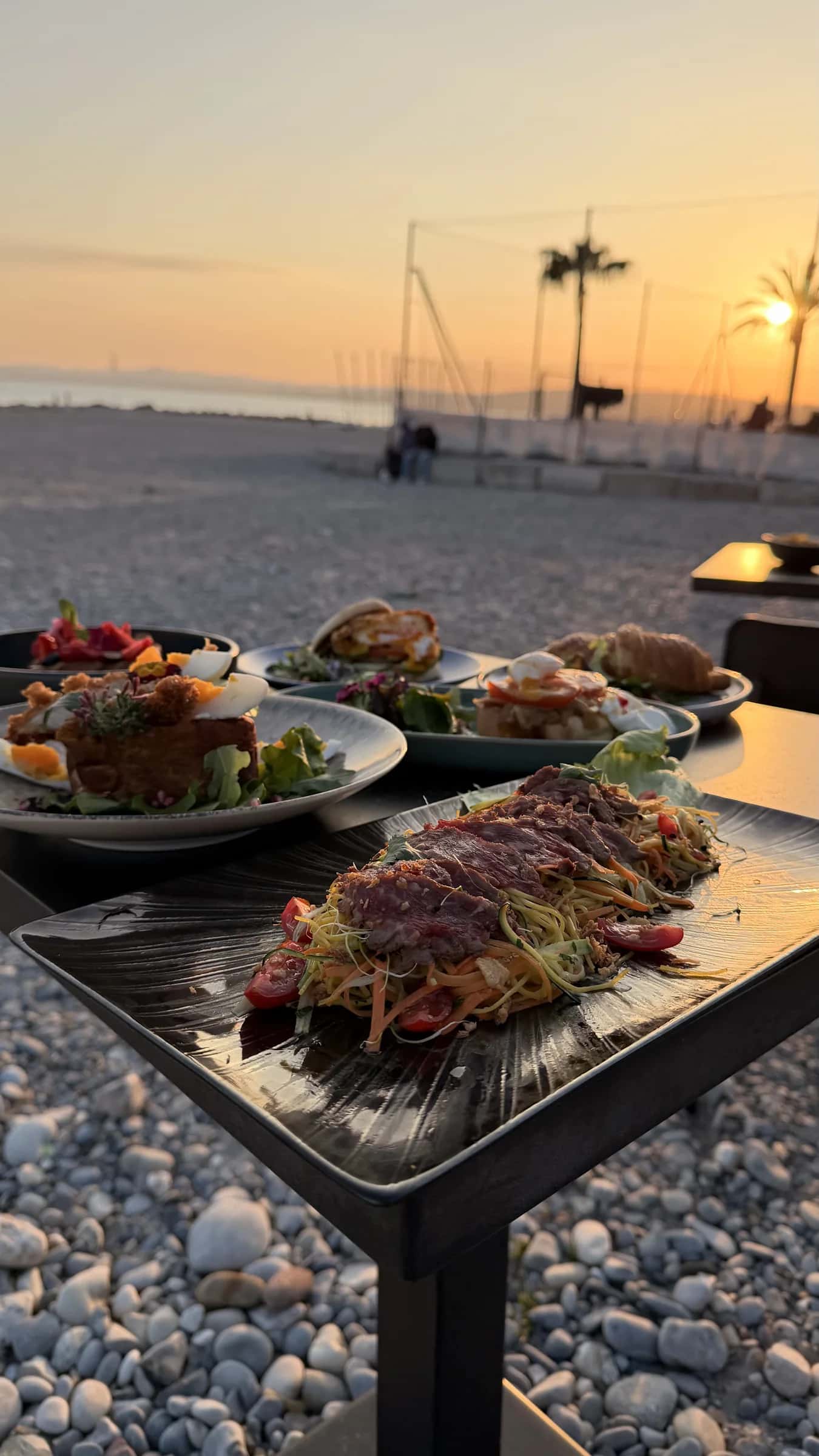 Table dressée face à la mer au coucher du soleil