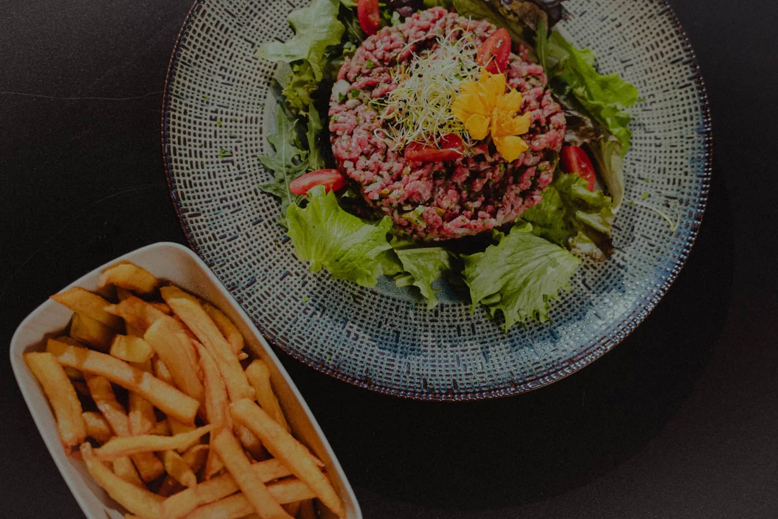 Tartare de bœuf et frites maison servis en terrasse